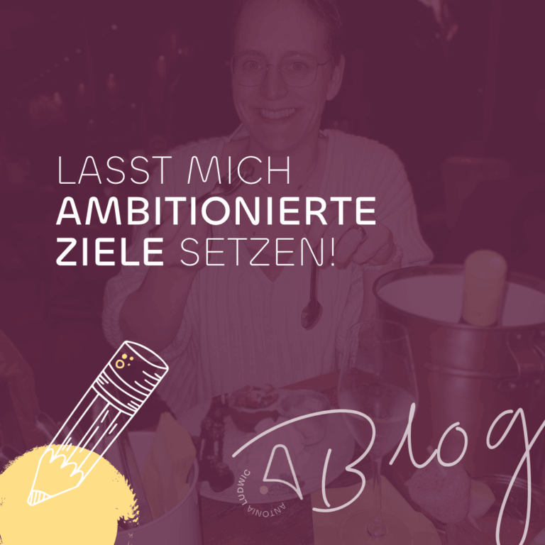 Antonia Ludwig lächelt bei einem gemütlichen Abendessen und hebt den Löffel, während der Text „Lasst mich ambitionierte Ziele setzen!“ eingeblendet ist – Symbolbild für ihren Blogartikel über gesunde Produktivität und den Mut zu großen Zielen.